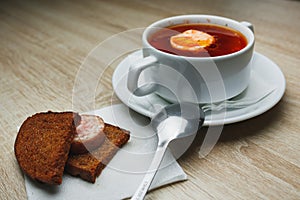 Ukrainian traditional borsch. Russian vegetarian red soup in white bowl on red wooden background. Top view. Borscht, borshch with