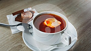 Ukrainian traditional borsch. Russian vegetarian red soup in white bowl on red wooden background. Top view. Borscht, borshch with