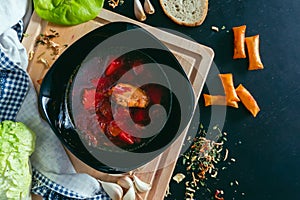 Ukrainian traditional dish borscht with garlic, herbs, bread and seasonings top view