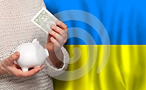 Ukrainian woman with money bank on the background of Ukraine flag. Dotations, pension fund, poverty, wealth, retirement concept