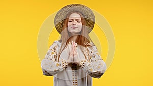 Ukrainian woman praying for Ukraine, victory, peace on yellow background. Girl begs God to save country, people