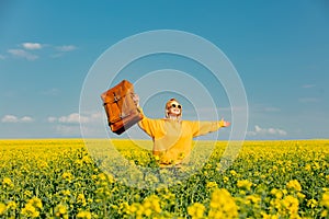 Ukrainian woman in yellow hoodie with bag in rapeseed field