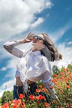 Ukrainian young  lady in white blouse in the field of poppies