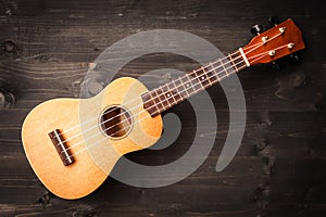 Ukulele on black wooden background. Acoustic music instruments. T