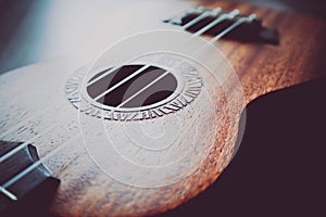 Ukulele guitar macro view, strings close up. Photo depicts music