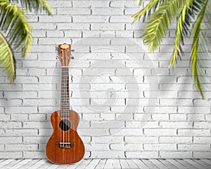 Ukulele guitar on a white wall background. Concept of travel and lifestyle.