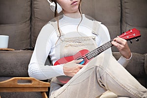 ukulele in women& x27;s hands, learning to play the ukulele close-up, Girl playing the ukulele, selective focus