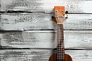 ukulele on a wooden background, stringed musical instrument