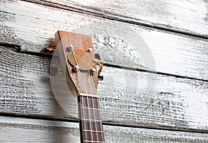 ukulele on a wooden background, stringed musical instrument