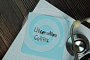 Ulcerative Colitis write on sticky notes isolated on Wooden Table. Medical or Healthcare concept