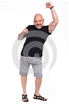 Ull portrait of a bald man with shorts and fist up on white background