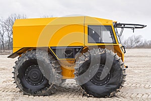 Ultimate all-terrain vehicle with huge big tires and strong yellow metal body
