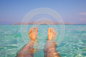 Ultimate holiday feeling, feet in clear blue water at a paradise and tropical location