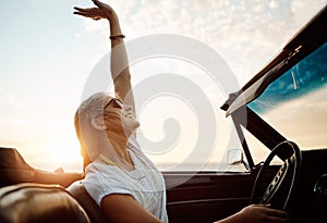 The ultimate season for fun. a happy young woman enjoying a summers road trip.