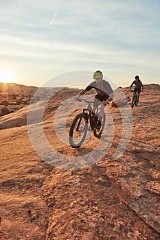 The ultimate test of endurance. Full length shot of two young male athletes mountain biking in the wilderness.