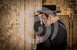 The ultra-orthodox Jewish man (haredi) praying with Tora in hand at Western wall (Wailing Wall) at Jerusalem.