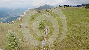 Ultra trail runners run uphill near the mountain top - 4k aerial view