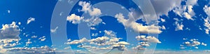 Ultra wide panorama of blue clear sky with gorgeous white clouds illuminated by the sun