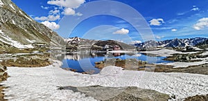 Ultra wide panorama of the lake in the Gotthardpass with snow