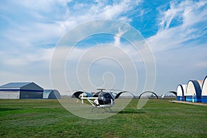 Ultralight white helicopter on green flying field in aeroclub