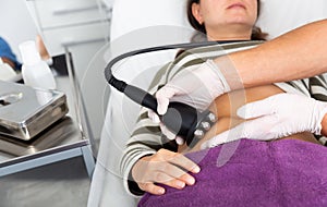 Ultrasonic fat cavitation procedure for female in cosmetology clinic