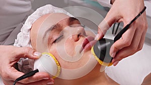 Ultrasonic scrabbing. Woman receiving ultrasound cavitation facial peeling and cleansing. Cosmetology and facial skin