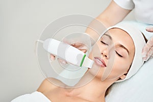 Ultrasound cosmetology scrubber. Face cavitation procedure.