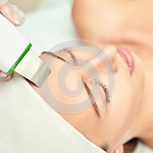 Ultrasound cosmetology scrubber. Face cavitation procedure.