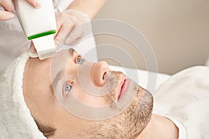 Ultrasound cosmetology scrubber. Face cavitation procedure. Salon skincare