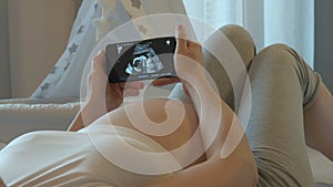 Ultrasound exam of unborn child on the smartphone screen