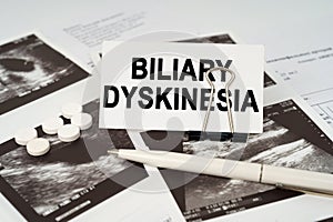 On the ultrasound pictures there is a pen and a business card with the inscription - Biliary dyskinesia