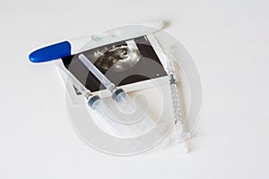 Ultrasound scan of baby and pregnancy test on white background