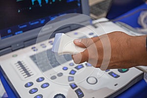 Ultrasound scanner in doctor hand for medical diagnostics with computer equipment