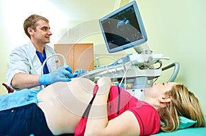 Ultrasound test. Pregnancy. Gynecologist checking fetal life with scanner.