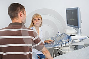 Ultrasunography doctor is explaining to the patientat divice