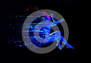 Ultraviolet black light glowing bodyart on young woman`s body. Dispersing girl on black background. Art creative concept