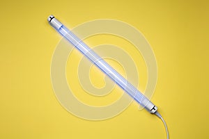 Ultraviolet lamp on yellow background, top view