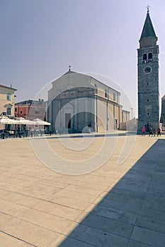 Umag town in Croatia, main square with church and tower at dusk