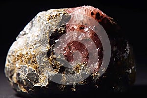 Umbite fossil mineral stone. Geological crystalline fossil. Dark background close-up.