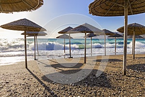 Umbreles on the sand beach with cloudy sky and sun