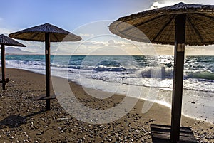 Umbreles on the sand beach with cloudy sky and sun