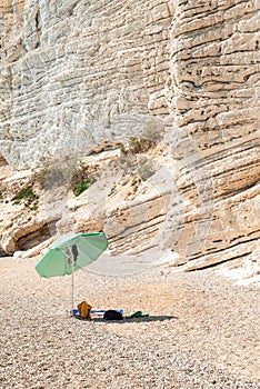 Umbrella on the beach coast of Mergoli, in the summer day. Baia delle Zagare in Puglia, Italy