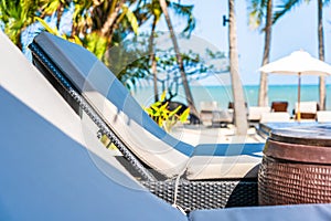 Umbrella and chair around swimming pool in hotel resort neary sea ocean beach for vacation