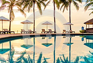 Umbrella and chair around swimming pool in resort hotel for leisure travel and vacation neary sea ocean beach