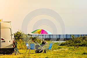 Umbrella with chairs at campervan on beach