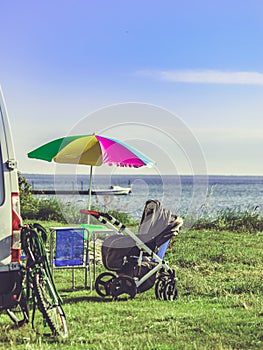 Umbrella with chairs at campervan on beach