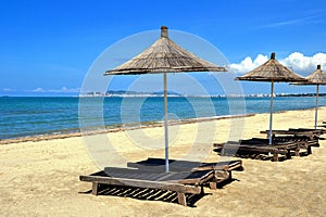 Umbrella and chaise lounges on the sandy beach.