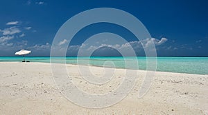 Umbrella on idyllic tropical sand beach.White beach umbrella and blue sky.Sun and umbrella on the beach.Summer beach.