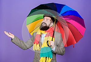 An umbrella is needed on a rainy day. Autistic or rain man holding colorful umbrella. Autism. Bearded man checking if it