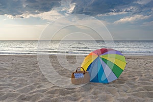 Umbrella and picnic basket against sea and beach